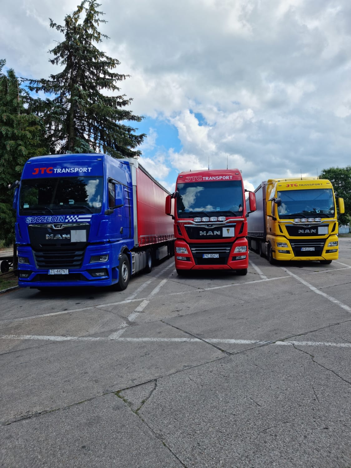 3 colored trucks are parked